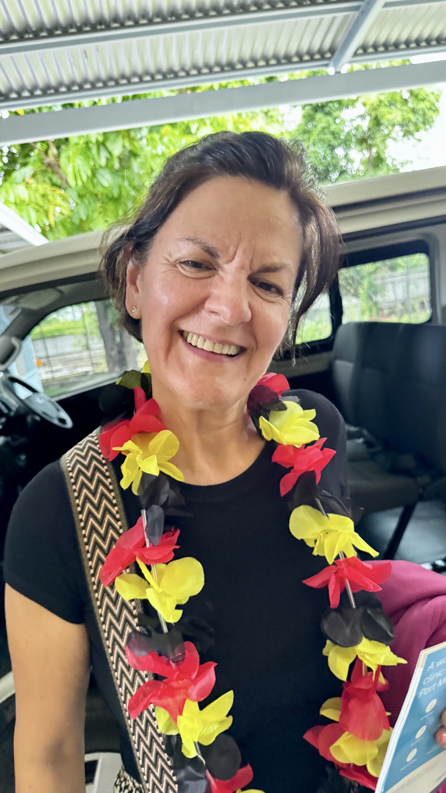 Miembro del equipo LearningFlow con collar de flores tradicional a su llegada a Papúa Nueva Guinea