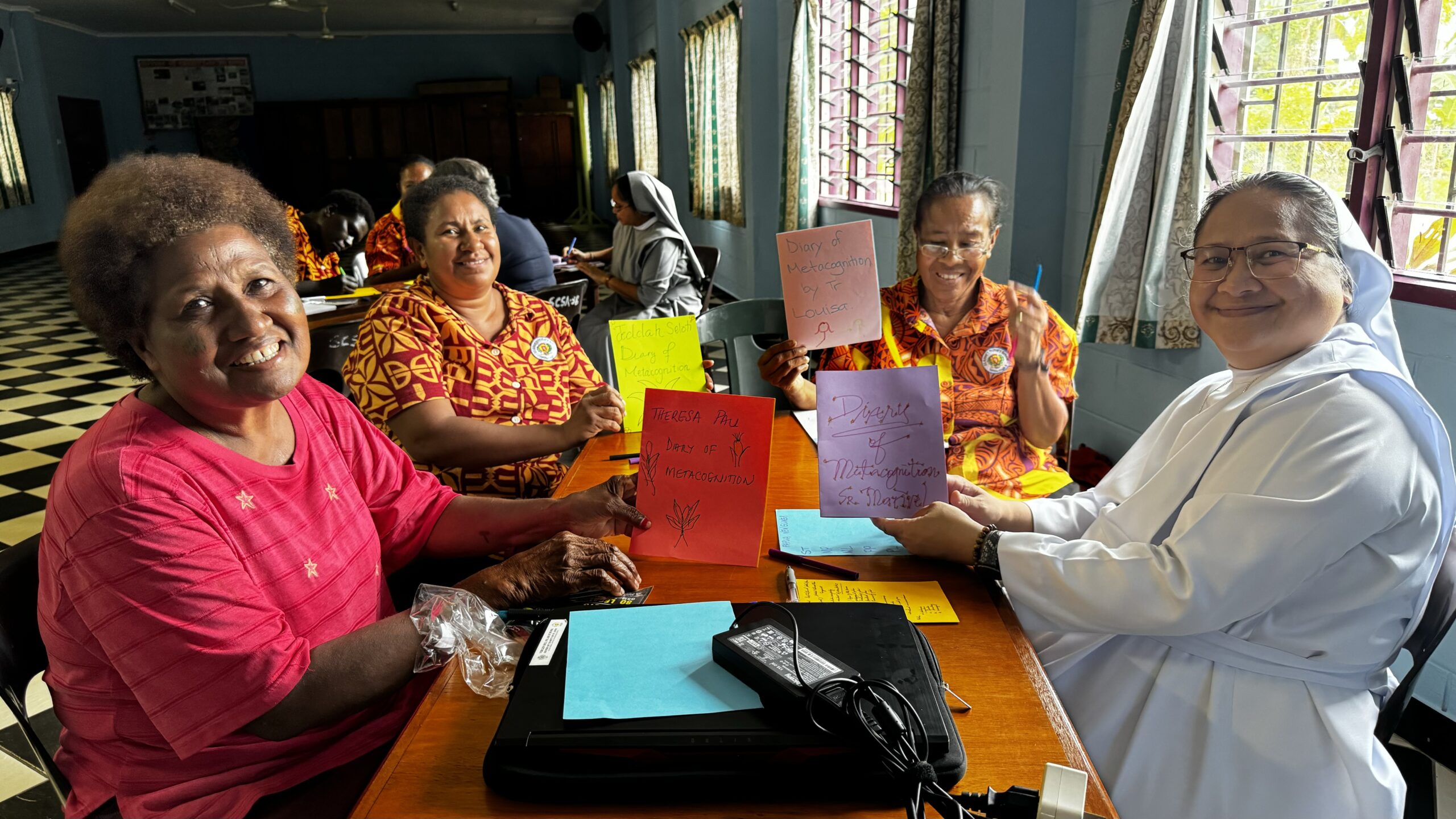 Educadoras del centro muestran sus Diarios de Metacognición elaborados durante el seminario PEI en Papua Nueva Guinea